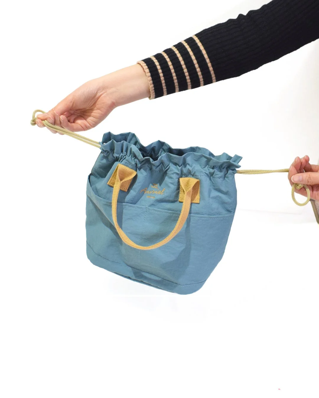 巾着バッグを持つ手元