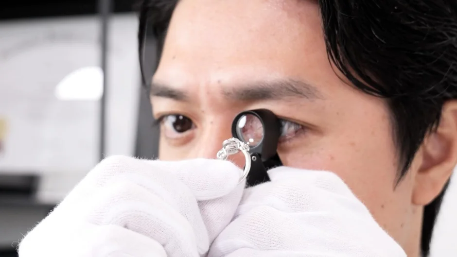 ダイヤモンドリングをルーペで鑑定する専門家