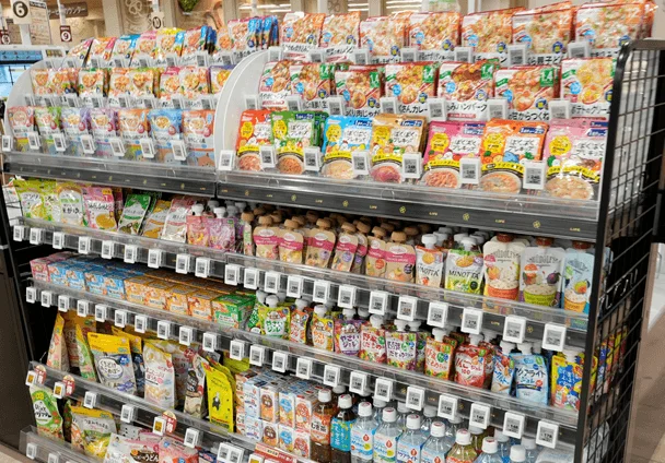 スーパーマーケットの棚に、多種多様なベビーフードやレトルトパウチ食品が整然と陳列されています。価格表示も見られ、買い物客向けの豊富な商品が並ぶ様子がうかがえます。
