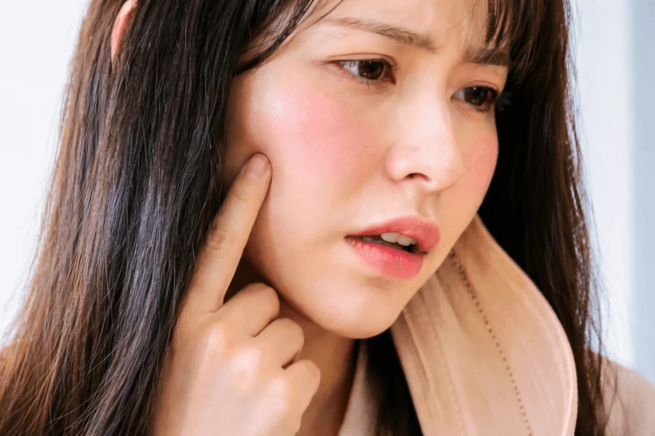 頬に指を当てる女性