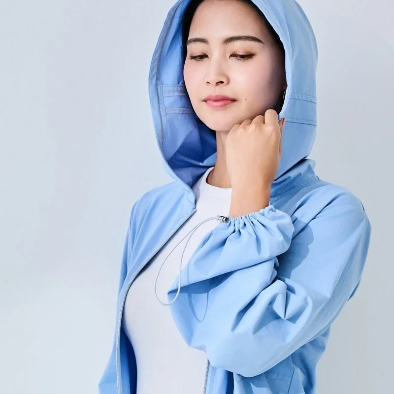 水色のフード付きジャケットを着用した女性のポートレートです。