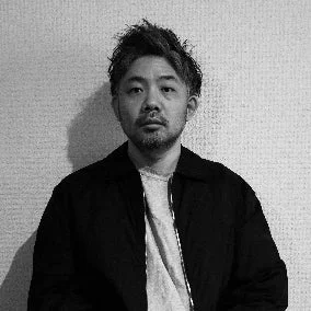 短髪でひげを生やしたアジア人男性のモノクロポートレート