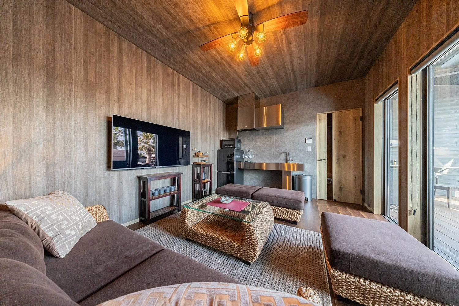 木目調の壁と天井が特徴的なモダンなリビング兼キッチン空間