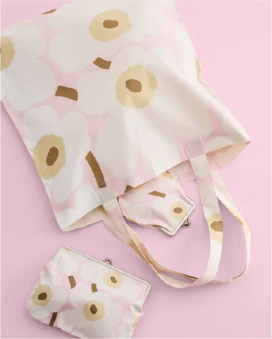 淡いピンクの背景に白い花柄のトートバッグとポーチ