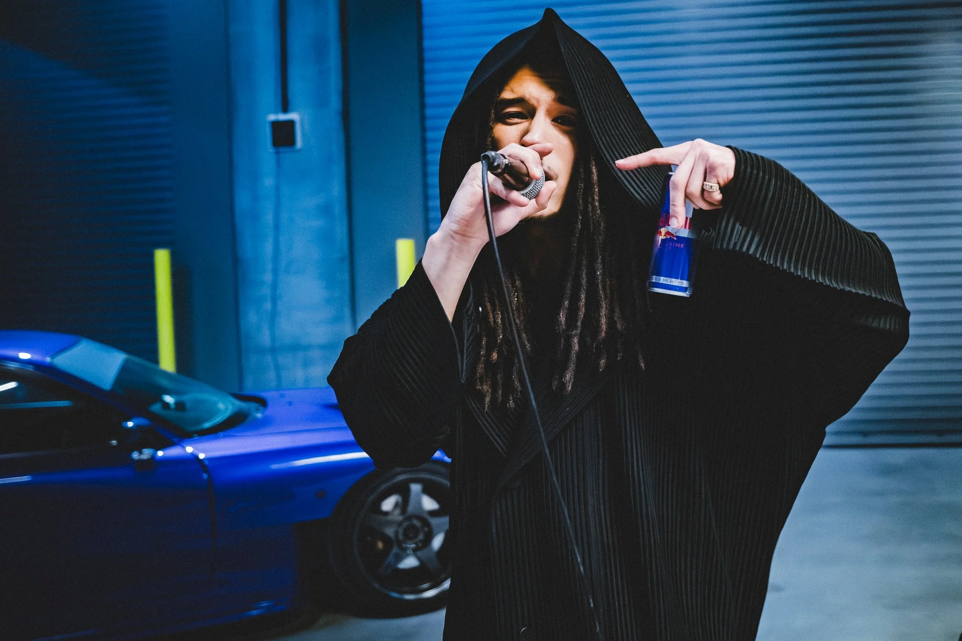 ドレッドヘアのラッパーと青い車