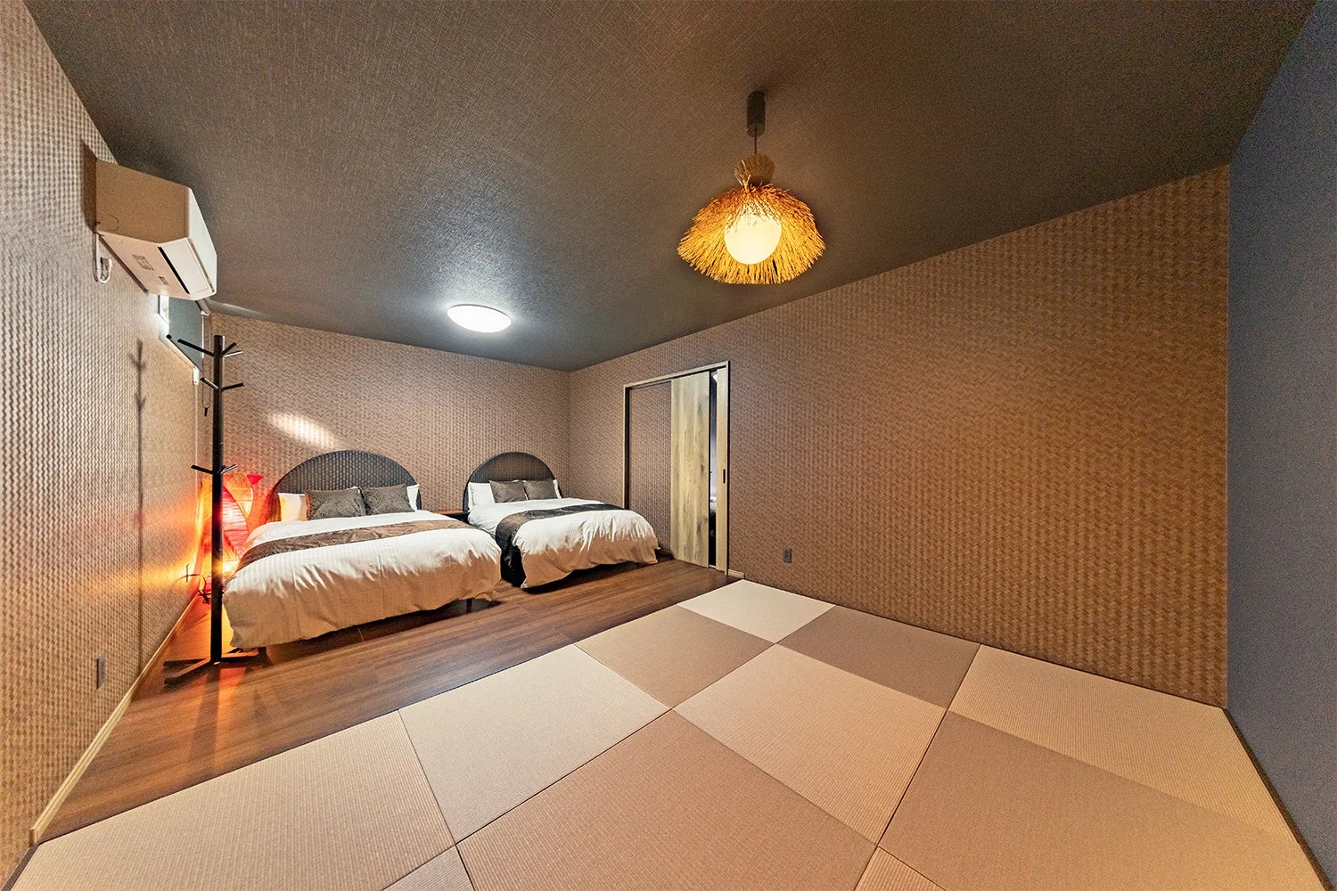 2つのベッドと畳スペースが設けられた、和モダンな雰囲気の寝室