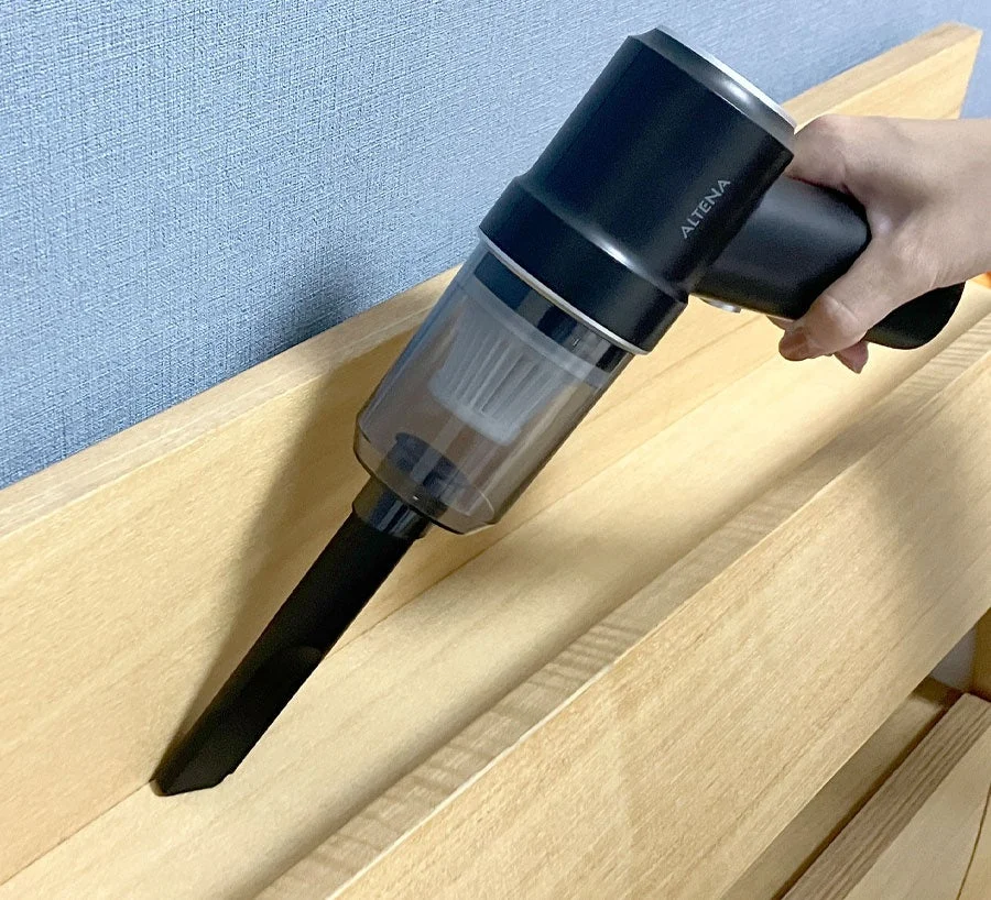 ハンディクリーナーで木製家具を掃除する様子