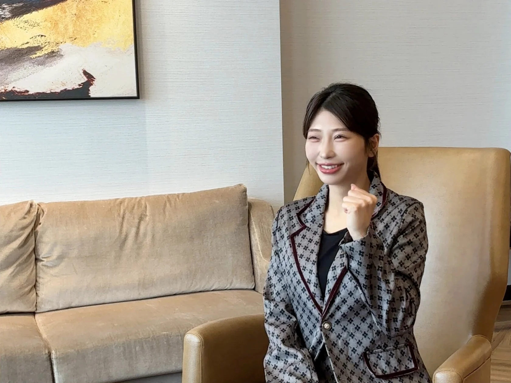 笑顔で拳を握り、前向きな姿勢を見せる水池愛香氏