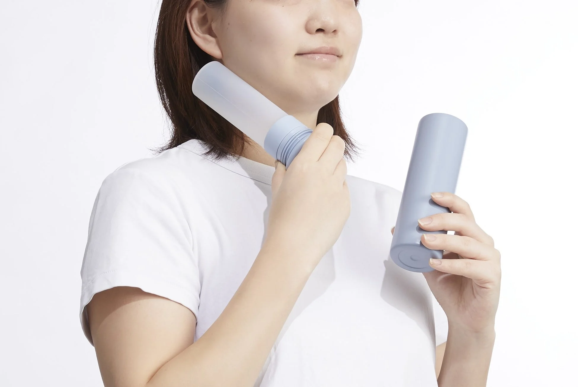 水色の円筒形アイテムを首元に当てる女性