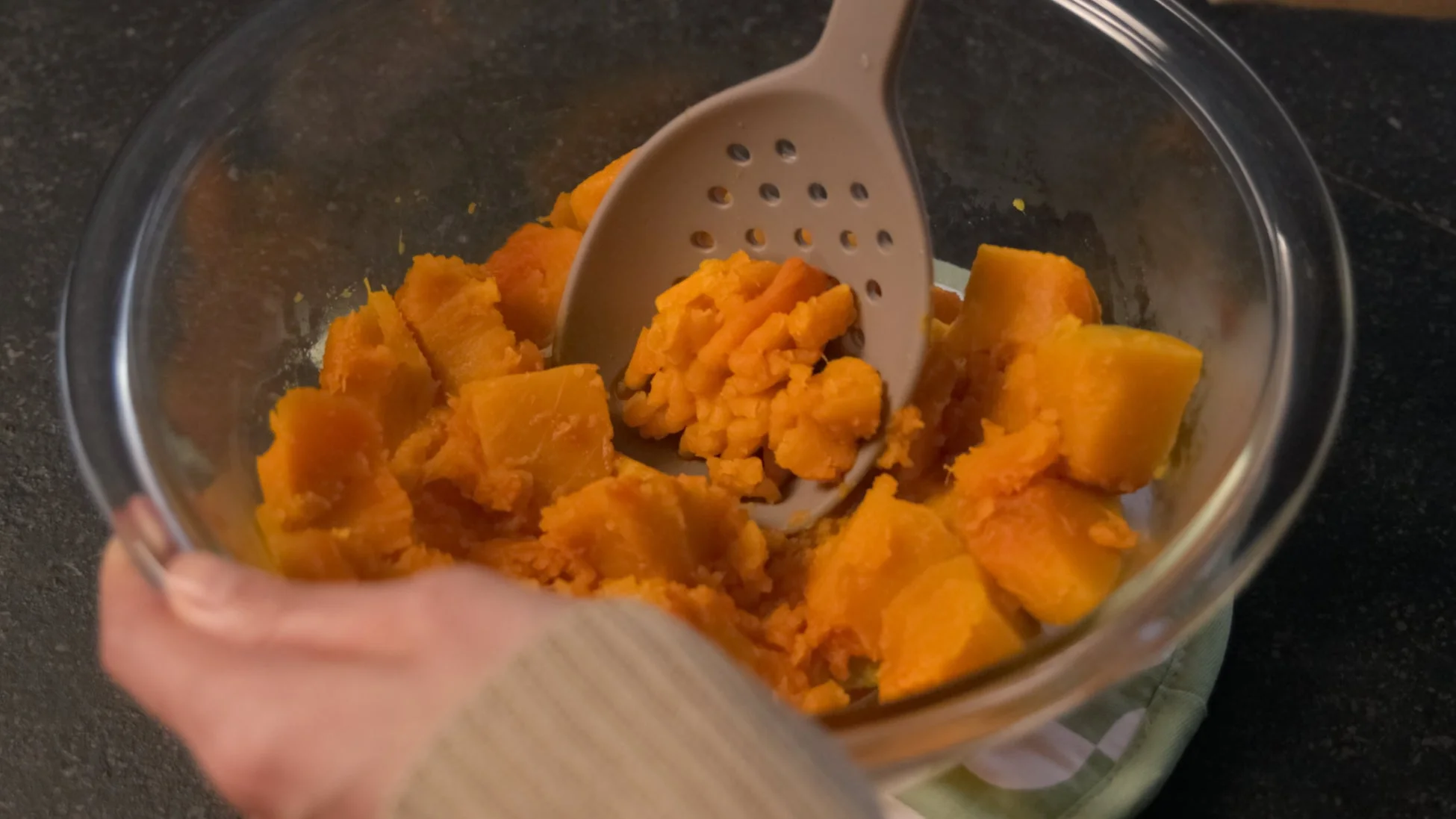 マッシャーにもなる穴あきレードルで野菜を潰す様子