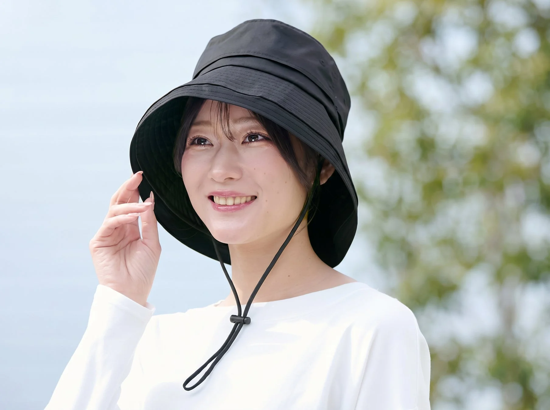 女性が黒いバケットハットをかぶっている