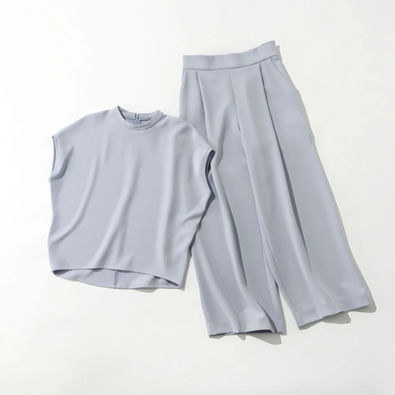 淡いブルーのノースリーブトップスとワイドパンツのセットアップ