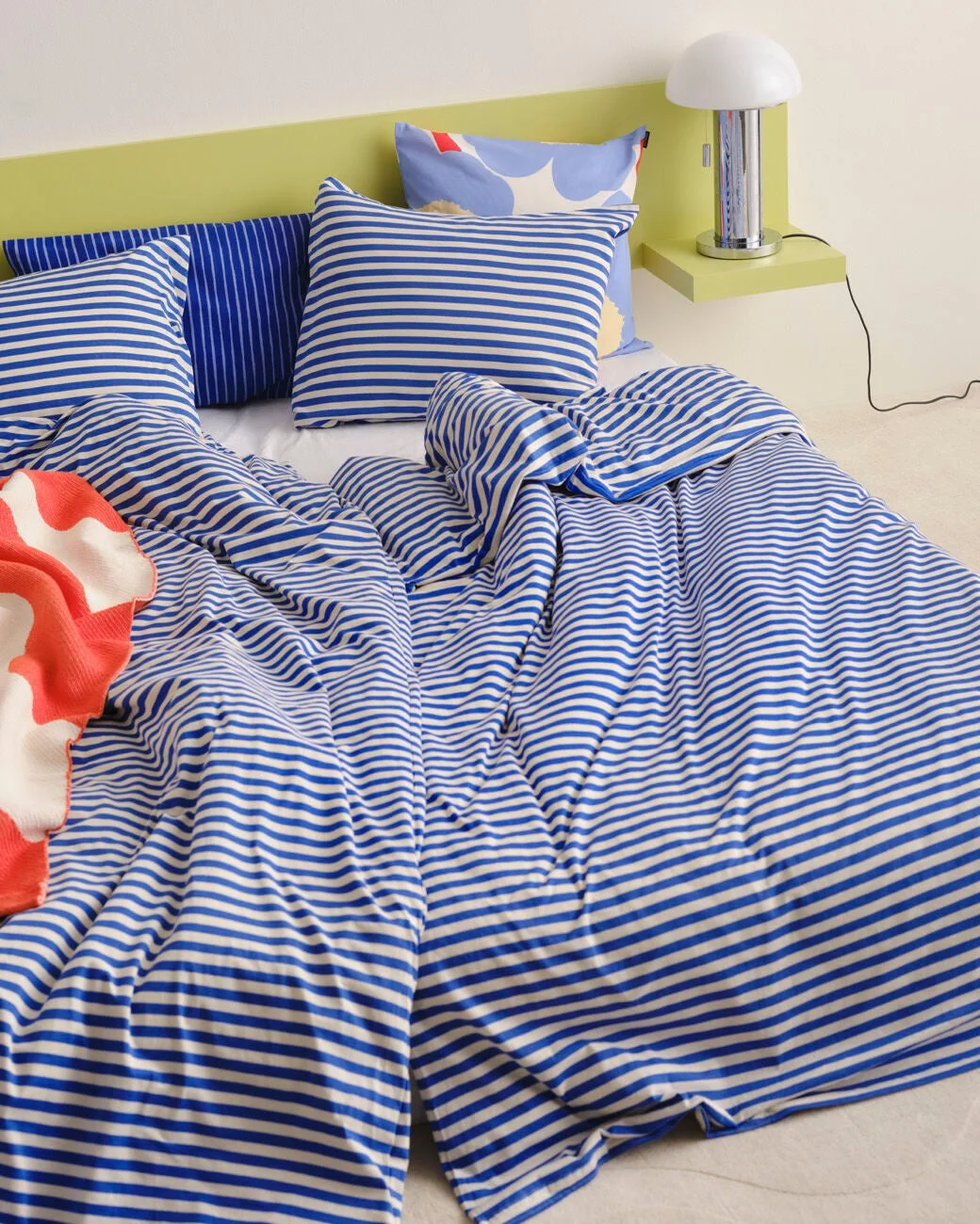 青と白のストライプ柄寝具のベッドルーム
