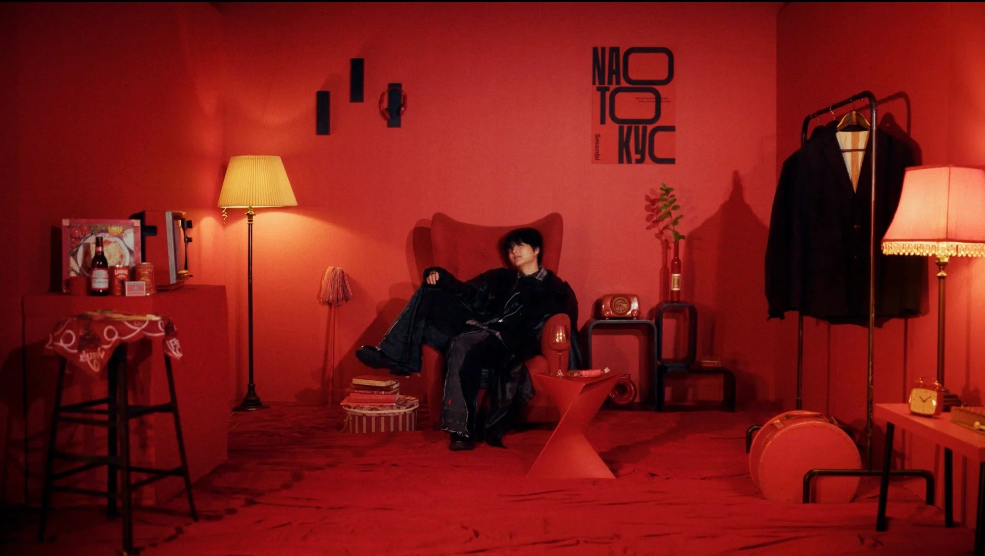 赤い部屋でアームチェアに座る男性