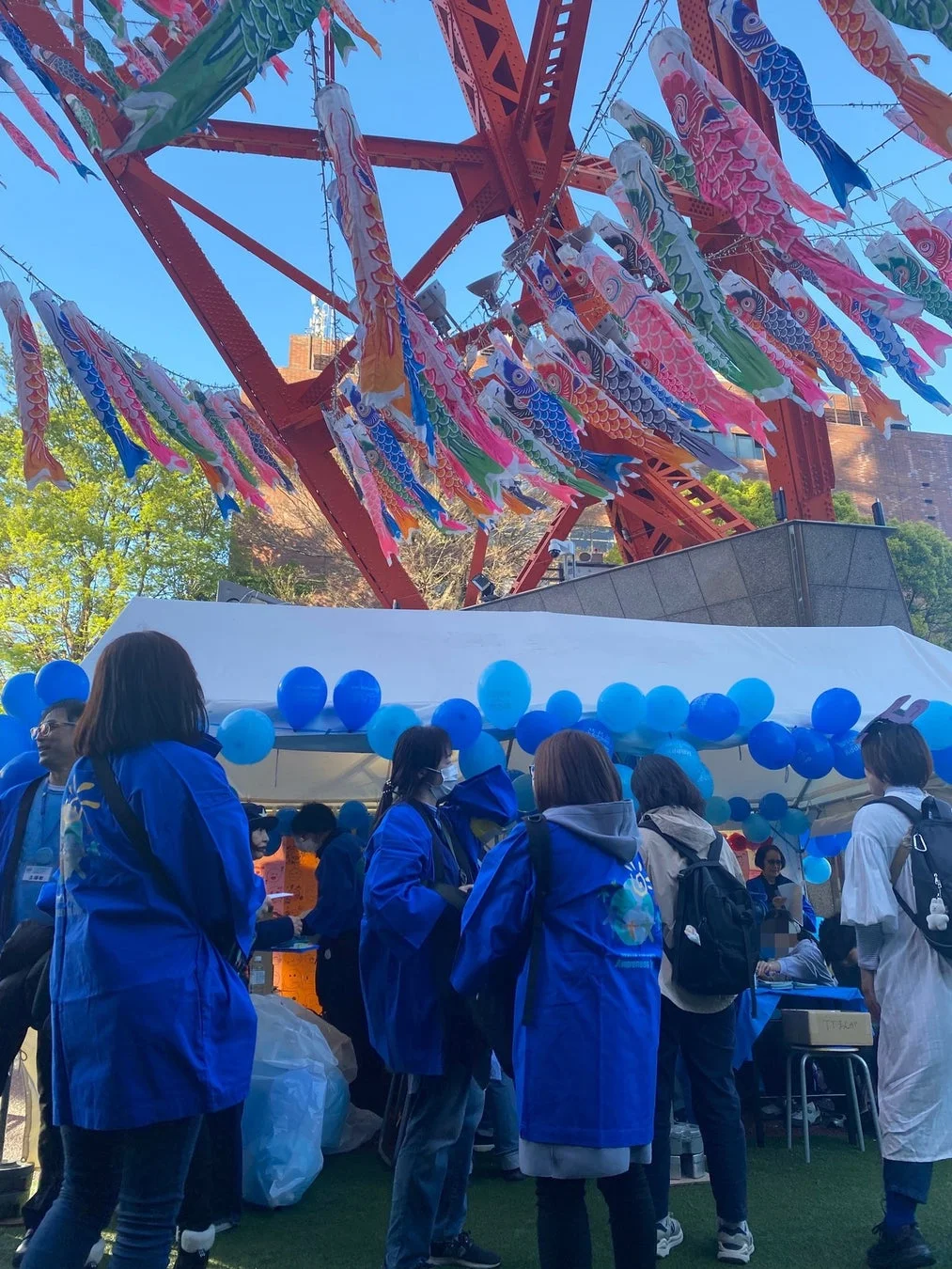 東京タワーと鯉のぼりの前でミス日本の方々が参加者と交流する様子