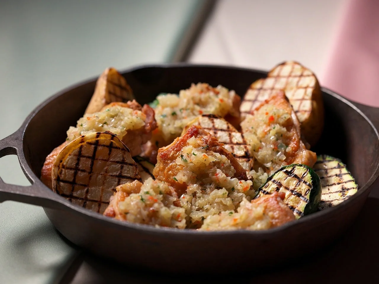 鉄鍋に盛り付けられたグリルされた肉と野菜