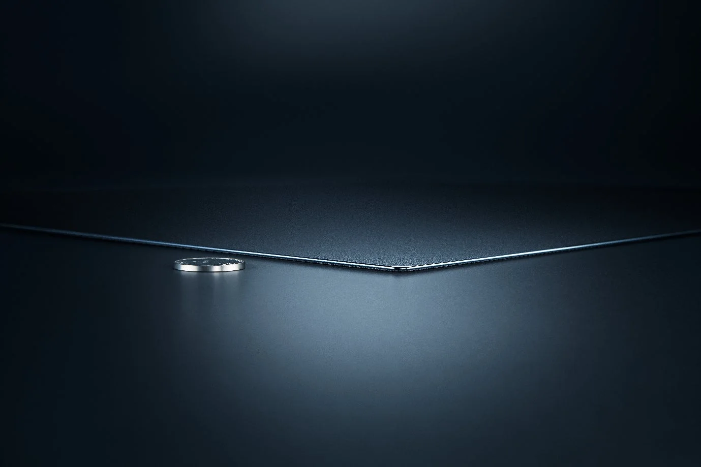 薄さを強調するコインとシートの画像