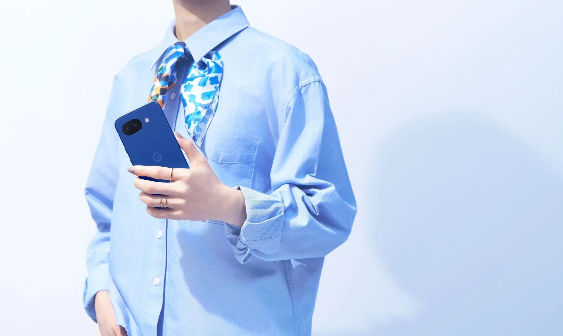 青いGoogle Pixelスマートフォンを手に持っている人物