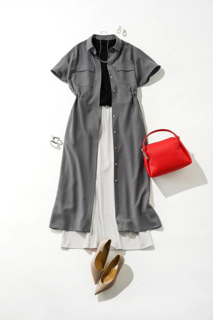 グレーのストライプ柄シャツワンピースを羽織り、白のパンツと黒のインナーを合わせた大人カジュアルなコーディネート