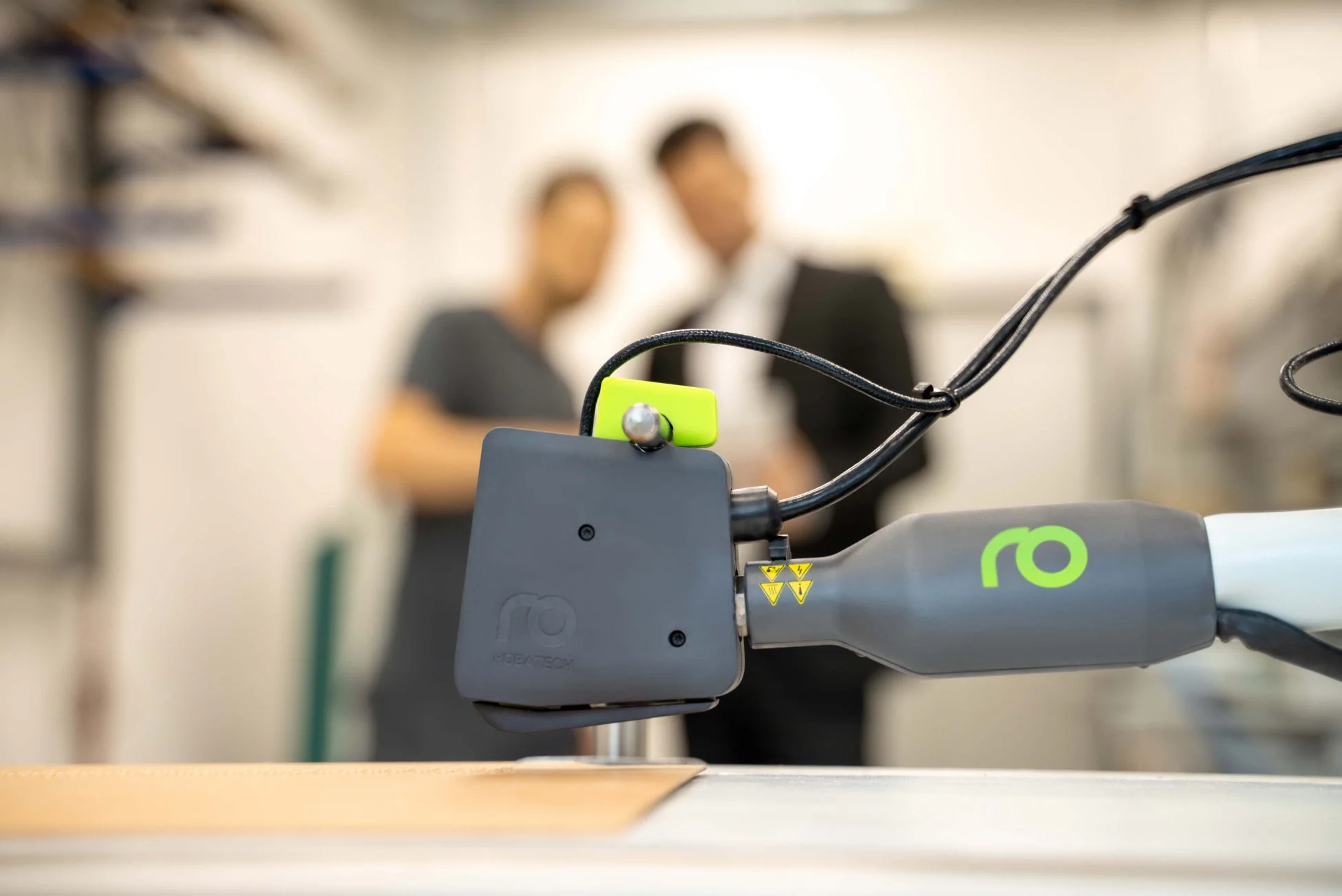 ロボットアームの先端部分がクローズアップされており、その下には素材が置かれている。