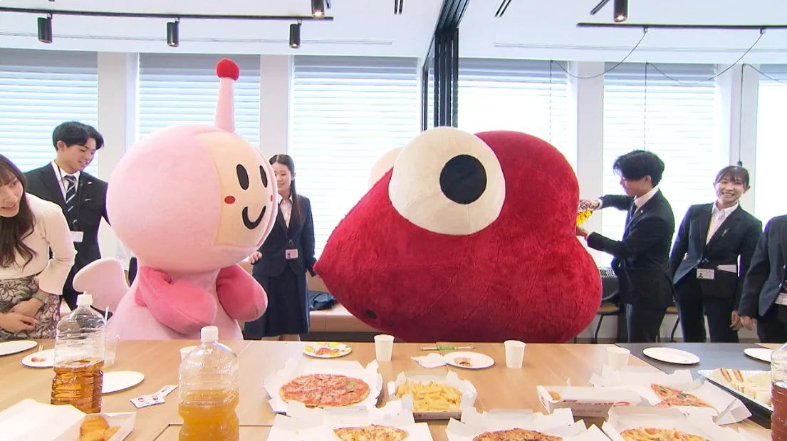 オフィスで交流するマスコットと社員たち