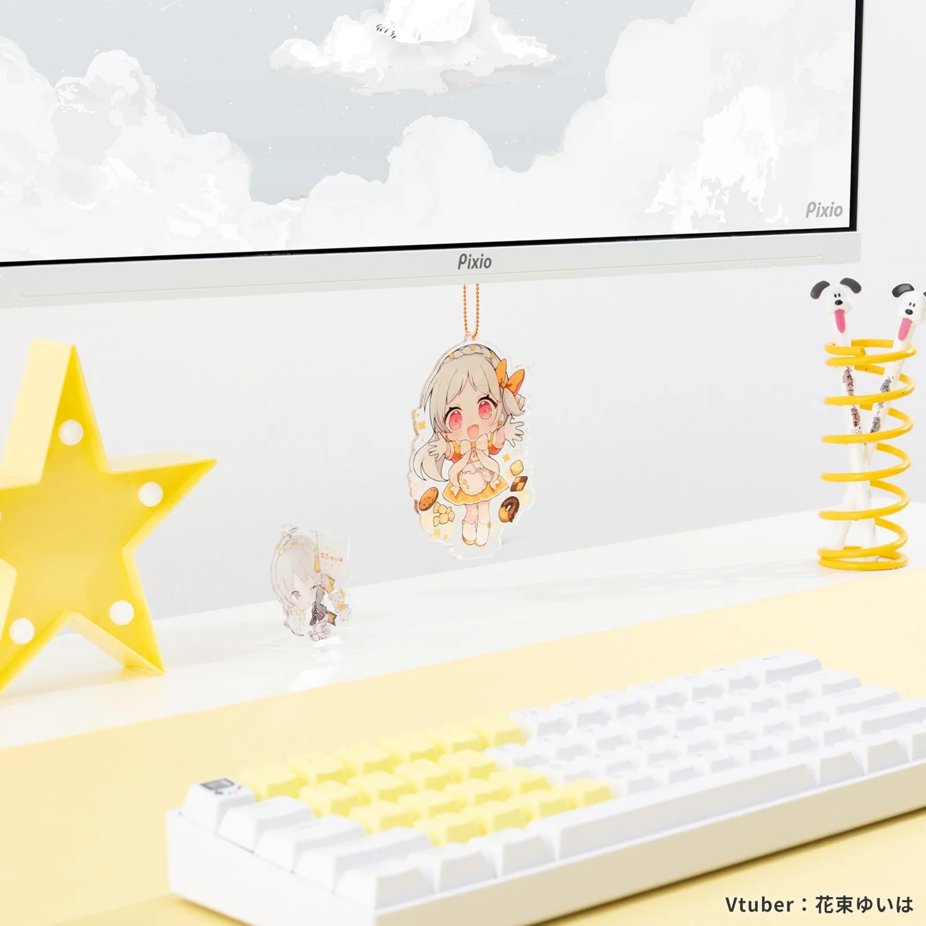 白いデスクに置かれたモニターとキーボード、黄色いアクセント