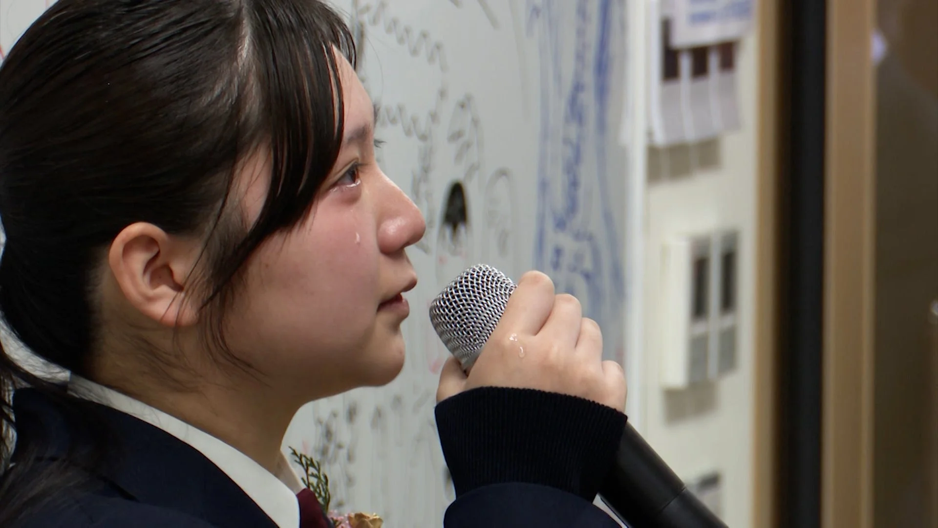 卒業式でスピーチをする女子学生