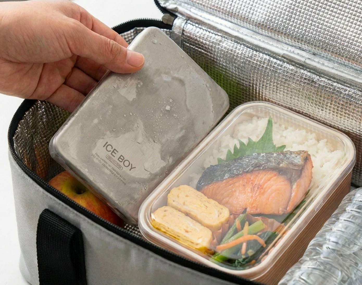 保冷バッグに鮭の塩焼きや卵焼きが入った弁当と保冷剤を詰めている様子