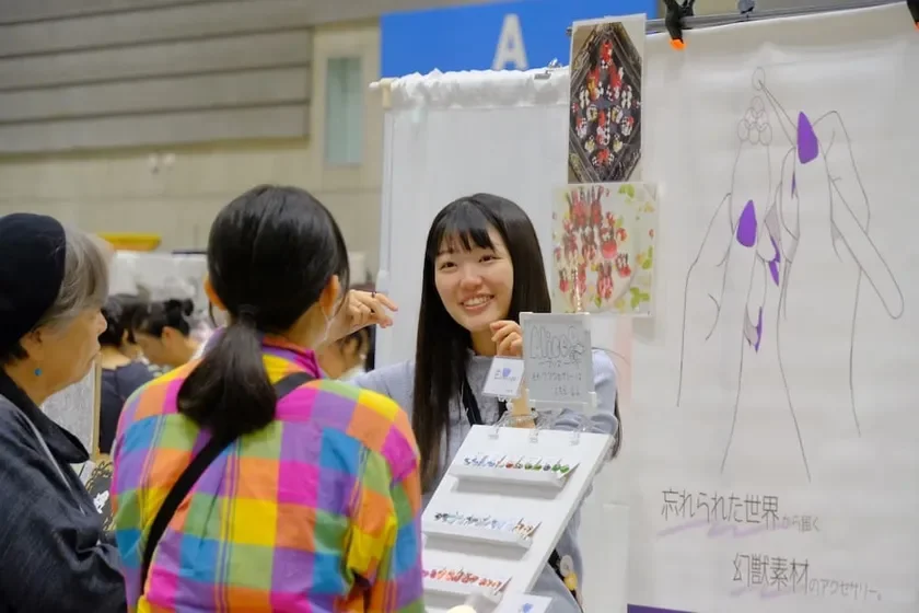 クラフトマーケットでアクセサリーを販売する女性
