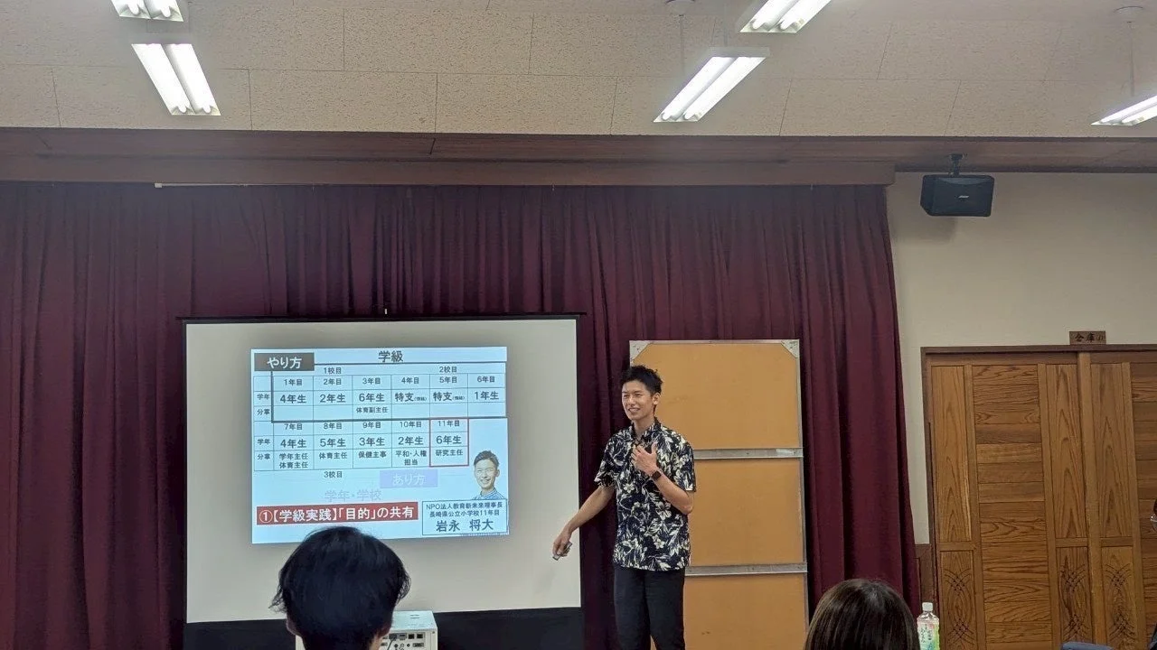 男性がプロジェクターを用いて教育に関するプレゼンテーションを行っている様子