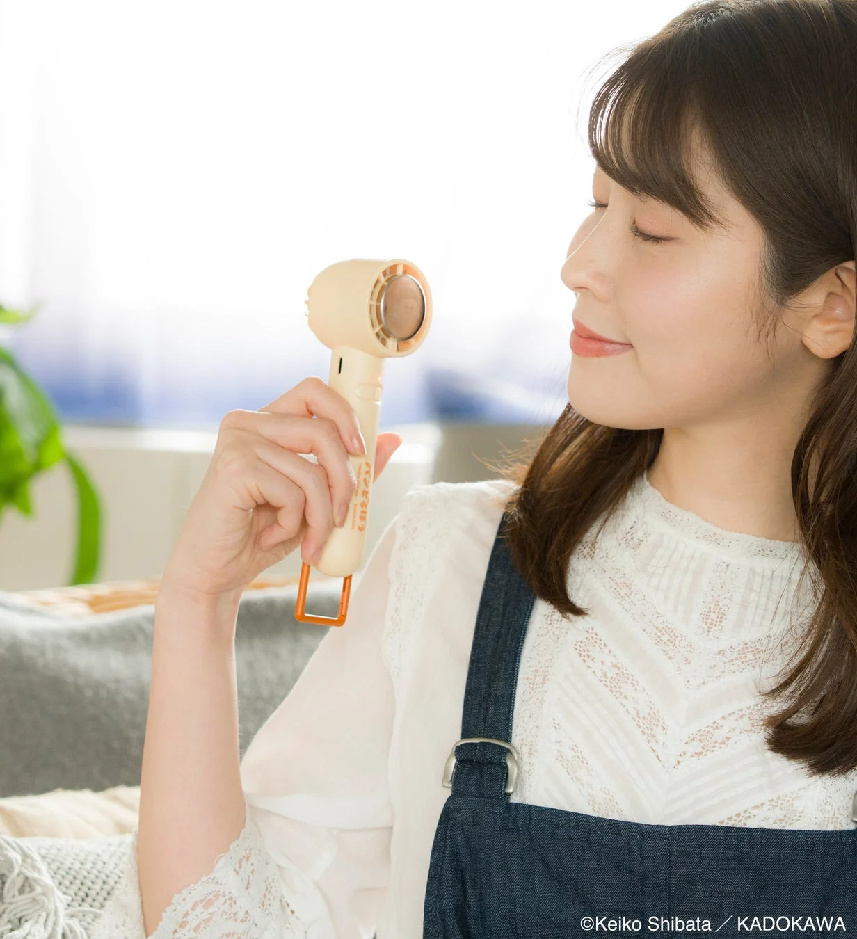 冷却プレート付きハンディーファンを使用する女性