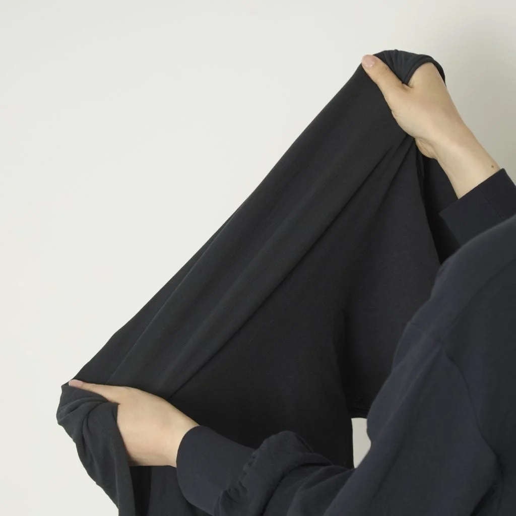 黒い柔らかい生地を両手で広げている様子
