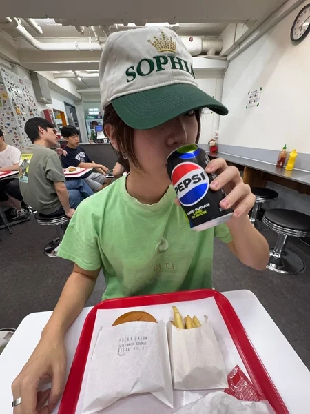 MASCOMPANYのキャップを被って食事をする人物