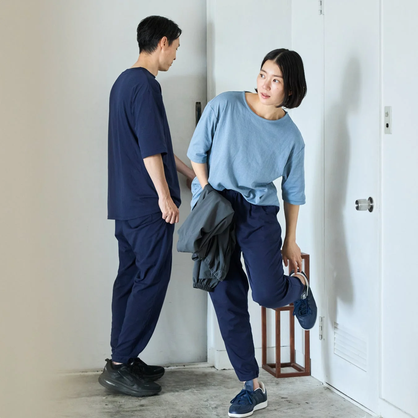 カジュアルな服装の男女が室内でくつろいでいる様子