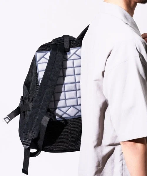 幾何学的なデザインのバックパネルを持つ黒いリュックサック