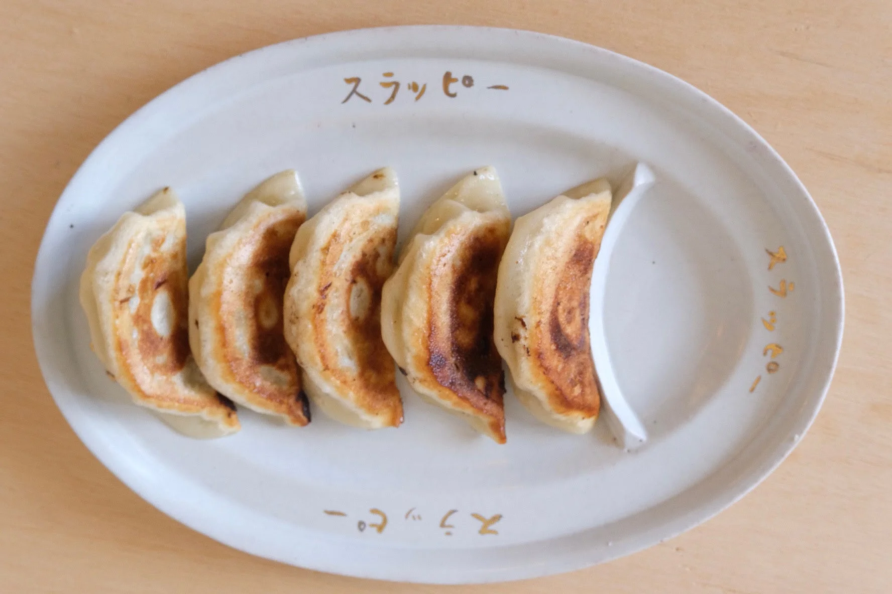 白い皿に盛り付けられた焼き餃子5個