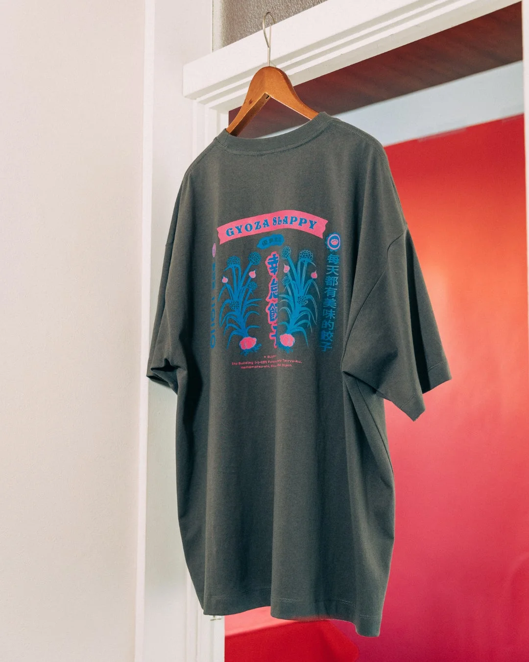 左胸に猫、背面にニンニクの花のグラフィックがデザインされたTシャツ