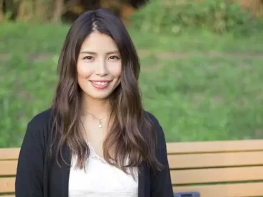 屋外の公園で、笑顔で座っている女性のポートレート